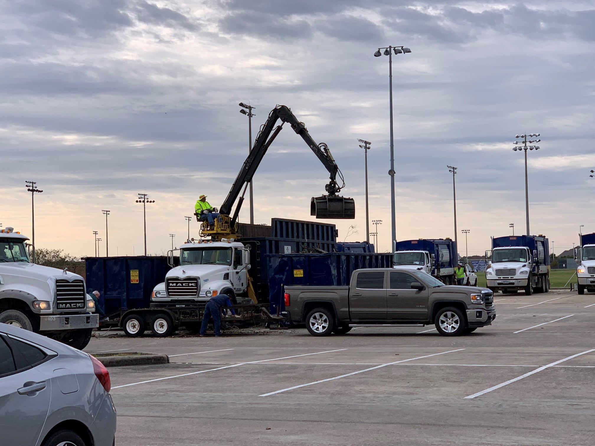 Crane removing trash from back of truck. 